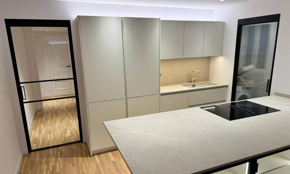 Reforma en cocina con puertas de acceso y paso en cristal con perfil negro